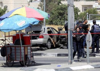 Las fuerzas de seguridad israelíes se reúnen en la escena de un ataque a la entrada del pueblo de Beit Anoun el 18 de julio de 2017. (Wisam Hashlamoun / Flash90)