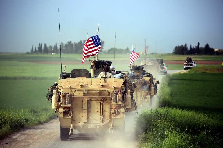 Las fuerzas estadounidenses, acompañadas por combatientes de las Unidades de Protección del Pueblo Kurdo (YPG por sus siglas en inglés), conducen sus vehículos blindados cerca de la aldea siria del norte de Darbasiya el 28 de abril de 2017. (AFP / Delil Souleiman)