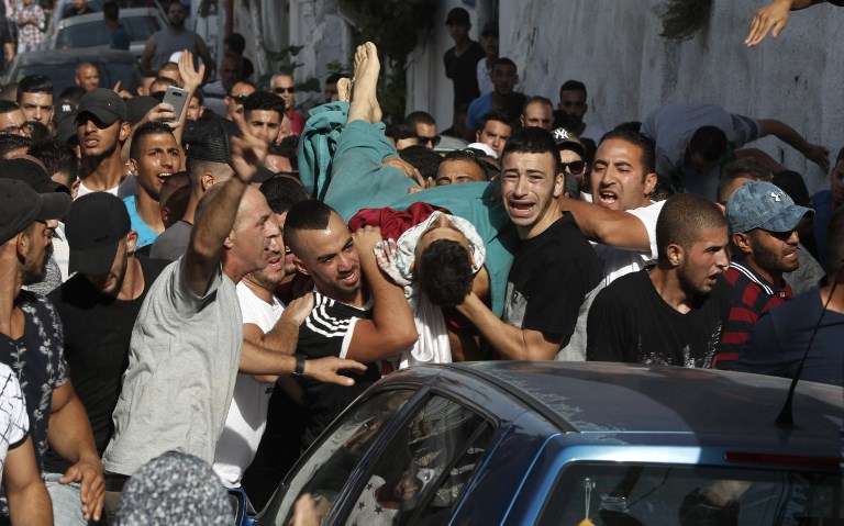 Los hombres árabes trasladan el cuerpo de Mohammed Abu Ghanem, quien murió durante los disturbios violentos contra las fuerzas israelíes, durante su entierro en la zona A-Tur de Jerusalén, el 21 de julio de 2017. (AFP / Ahmad Gharabli)