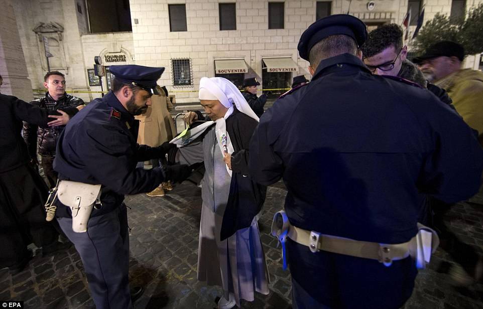 La policía inspecciona a una monja antes de su ingreso a la “Plaza de San Pedro”. (Foto: EPA / www.dailymail.co.uk)