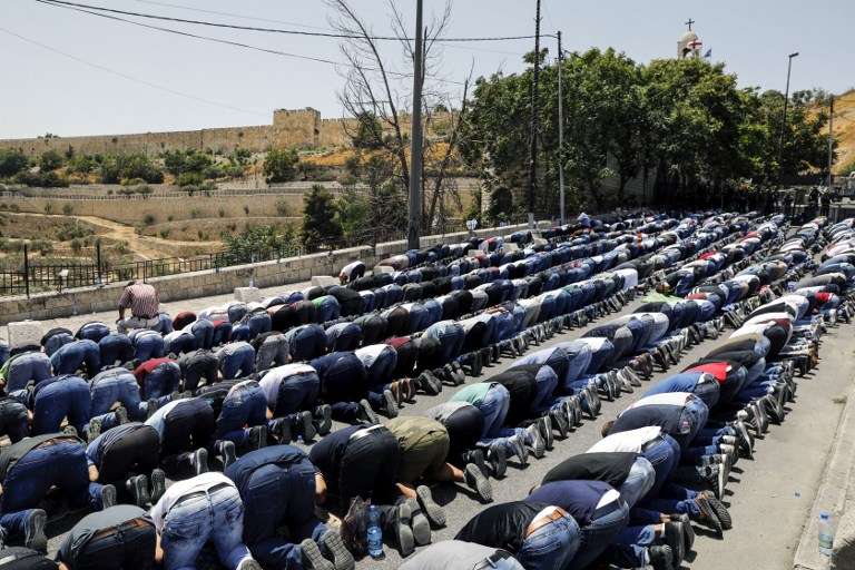 Musulmanes rezan fuera de la Ciudad Vieja de Jerusalén cerca de la Puerta de los Leones el 28 de julio de 2017. (AFP PHOTO / MENAHEM KAHANA)