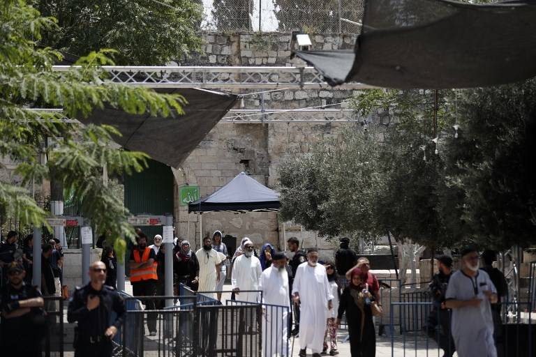 Turistas musulmanes transitan más allá de medidas de seguridad israelíes mientras que salen del Monte del Templo en la ciudad vieja de Jerusalén el 23 de julio de 2017. (AFP PHOTO / Ahmad Gharabli)