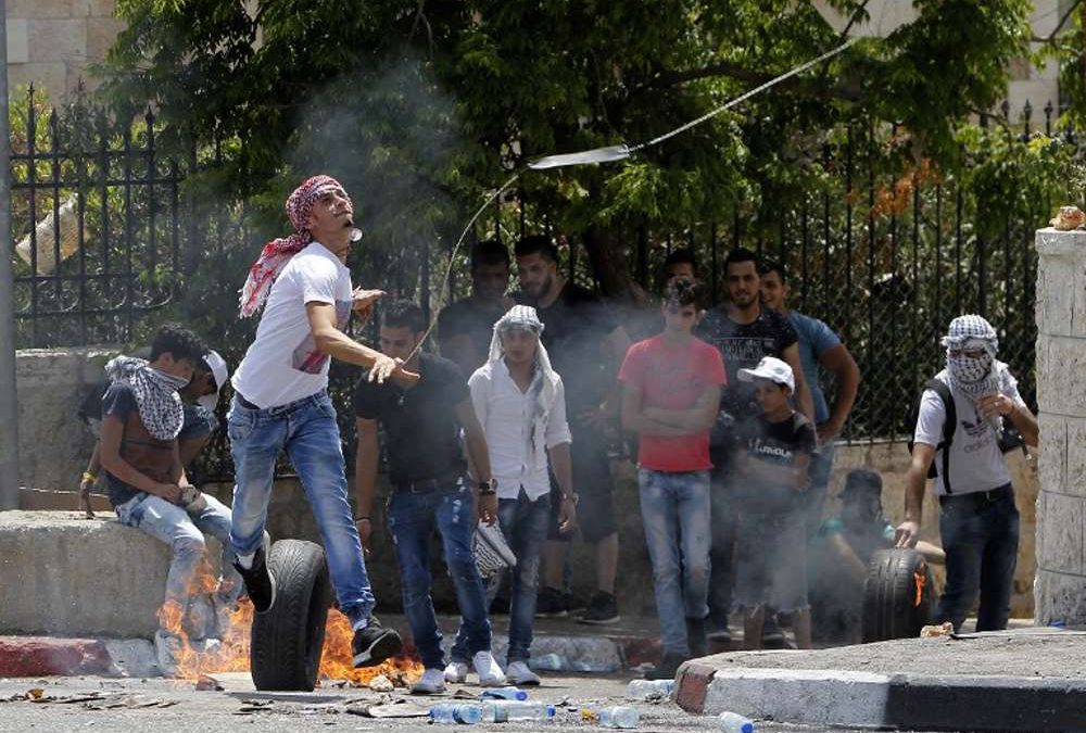 Un árabe lanza una piedra con una honda contra las fuerzas israelíes durante las violentas manifestaciones después de las oraciones islámicas del viernes en la entrada principal de la ciudad de Belén el 21 de julio de 2017. (AFP / Musa Al Shaer)