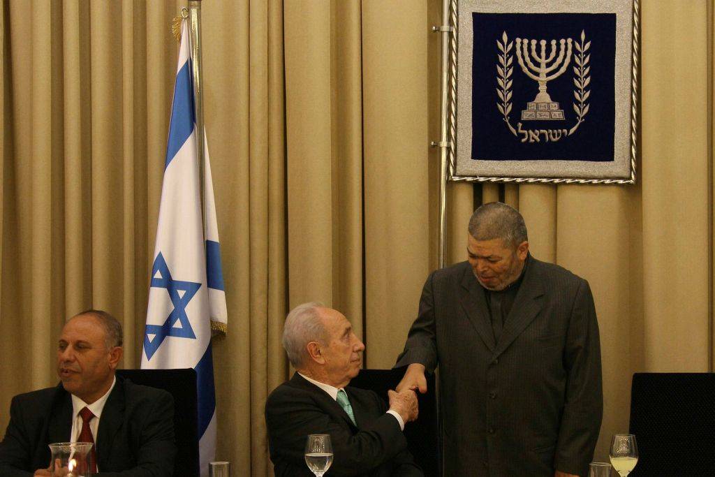 El ex presidente de Israel, Shimon Peres, estrecha la mano con el jeque Abdullah Nimr Darwish (R) durante una comida Iftar en la residencia del presidente en Jerusalén el 9 de septiembre de 2008. (Anna Kaplan / Flash90)