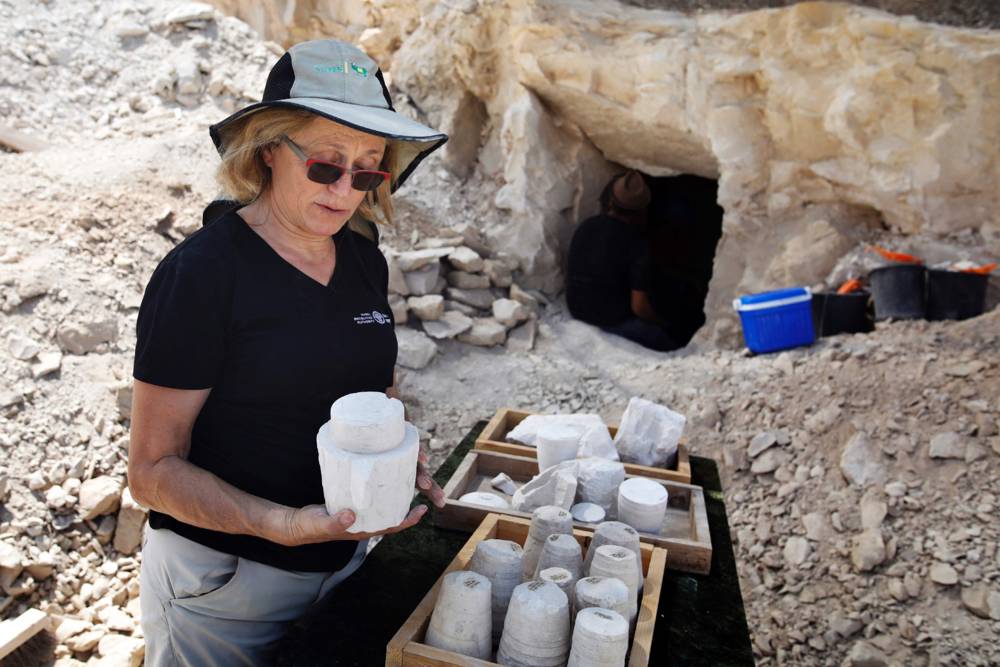 La arqueóloga Yardenna Alexandre inspecciona los núcleos de piedra de cal y las tazas descubiertas en un sitio de excavación que data del período romano en Reineh, el 10 de agosto de 2017. MENAHEM KAHANA / AFP