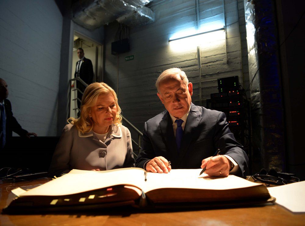 El primer ministro israelí Benjamin Netanyahu y su esposa Sara firman el libro de invitados durante una visita a la embajada de Israel en Buenos Aires, Argentina, el 11 de septiembre de 2017 (Avi Ohayon / GPO)