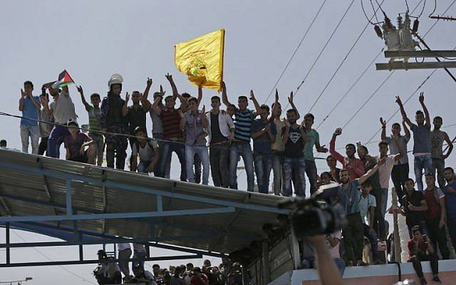 Los árabes se reúnen en el cruce fronterizo de Erez mientras el convoy de la Autoridad Palestina de Rami Hamdallah llega a Beit Hanun, en el norte de la Franja de Gaza, el 2 de octubre de 2017. (AFP Photo / Mahmud Hams)