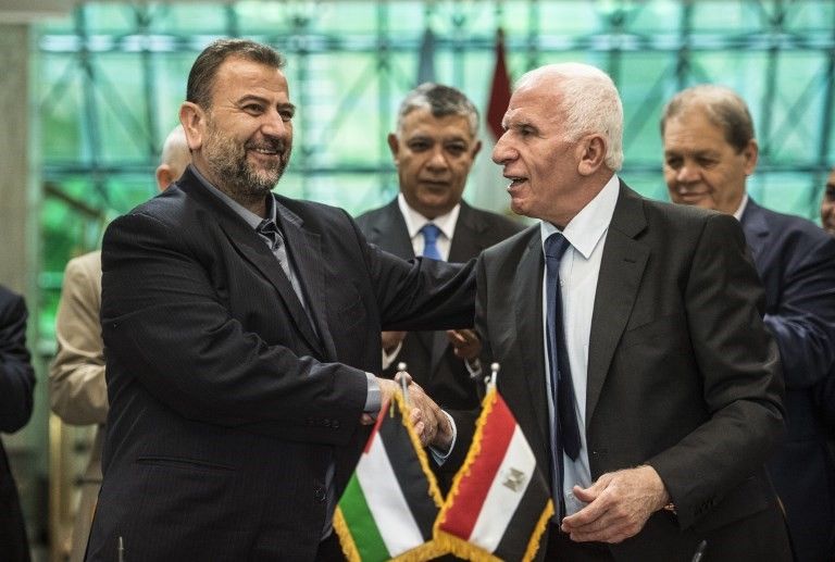 Azzam al-Ahmad, de Fatah (derecha), y Saleh al-Arouri, a la izquierda, de Hamás estrechan la mano después de firmar un acuerdo de reconciliación en El Cairo el 12 de octubre de 2017, cuando los dos movimientos árabes rivales terminaron su década de división tras las negociaciones supervisadas por Egipto . (AFP / Khaled Desouki)