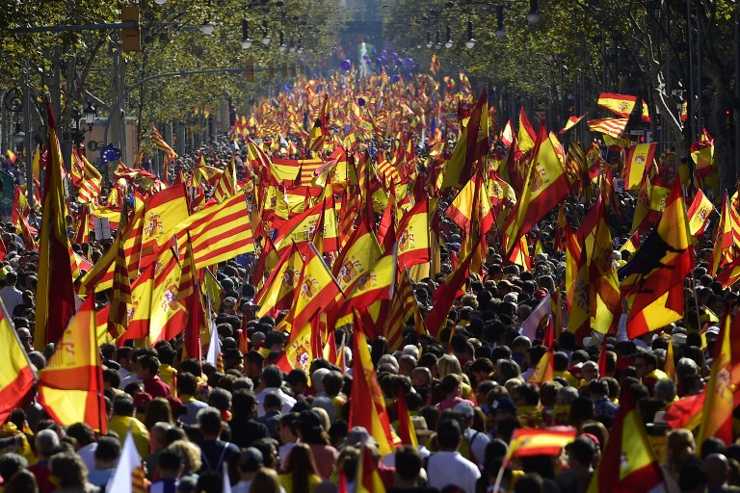 Los manifestantes ondean las banderas Senyera españolas y catalanas durante una manifestación pro unidad en Barcelona el 29 de octubre de 2017. (AFP PHOTO / PIERRE-PHILIPPE MARCOU)