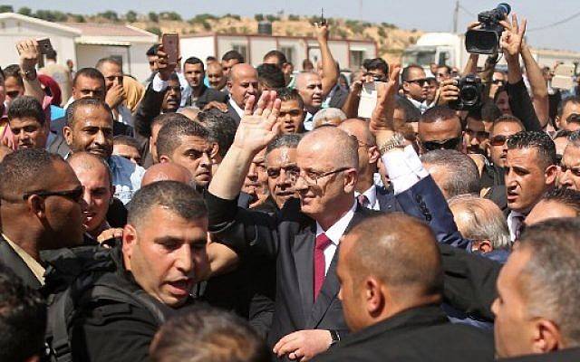 El primer ministro de la Autoridad Palestina, Rami Hamdallah (C), está rodeado de seguridad mientras llega al paso fronterizo de Erez en Beit Hanoun, en el norte de la Franja de Gaza, el 2 de octubre de 2017. / AFP PHOTO / MAHMUD HAMS