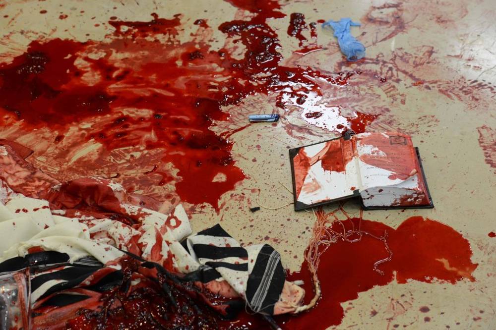 Sangre en los mantos de oración y libros de rezos dentro de la sinagoga Kehilat Yaakov de Har Nof, donde dos terroristas musulmanes atacaron a los fieles rezando, mataron a cuatro y un policía que intentó frustrarlos, el 18 de noviembre de 2014. (Crédito de la foto: Kobi Gideon / GPO / FLASH90)