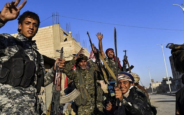 Los miembros de las Fuerzas Democráticas Sirias (SDF), respaldados por las fuerzas especiales de los EE. UU., Celebran la victoria contra el Estado Islámico derrumbando la fortaleza de Raqqa el 16 de octubre de 2017. (AFP PHOTO / BULENT KILIC)