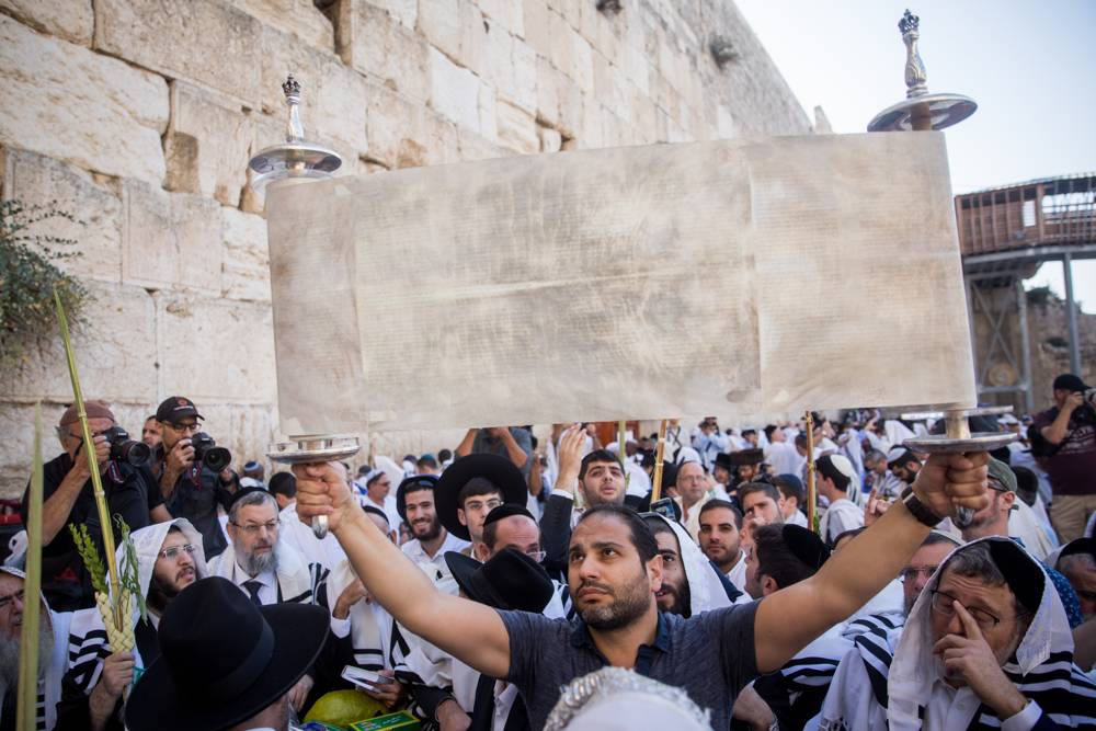 Judíos sostienen el rollo de la Torá en la bendición sacerdotal anual durante la festividad de Sukkot en el Muro Occidental en la Ciudad Vieja de Jerusalén el 8 de octubre de 2017. (Yonatan Sindel / Flash90)