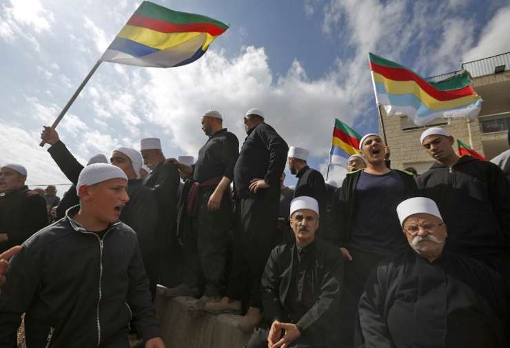 Hombres drusos israelíes en los Altos del Golán se congregan cerca de la frontera con Siria, ondeando la bandera de su comunidad, después de enterarse de un atentado suicida en la aldea siria drusa de Hadar, el 3 de noviembre de 2017. (Jalaa Marey / AFP)