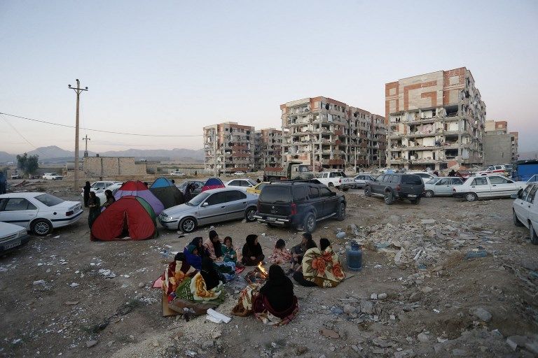 Los residentes se amontonan junto a un fuego en un área abierta después de un terremoto de magnitud 7.3 en Sarpol-e Zahab en la provincia iraní de Kermanshah el 13 de noviembre de 2017. (AFP / ISNA / POURIA PAKIZEH)