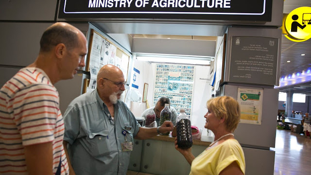 Shuki Kedmi explica a una pareja que vuelve de San Petersburgo por qué su bebida embotellada no será permitida en Israel. [Foto: Ofer Vaknin]