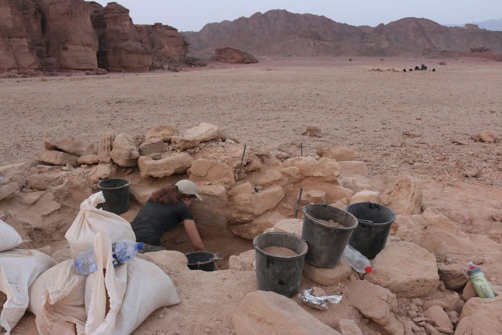 Excavando el túmulo sepulcral de la mujer embarazada encontrada en Timna. El templo de Hathor y la formación de arenisca conocida como "Pilares de Salomón" están a la izquierda. (Crédito: Central Timna Valley Project)