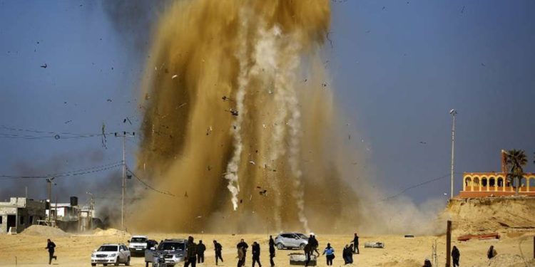 Ilustrativo: Árabes huyen mientras la arena y el humo suben después de un ataque aéreo israelí contra un puesto de Hamás en el norte de la Franja de Gaza el 6 de febrero de 2017. (Mohammed Abed / AFP)