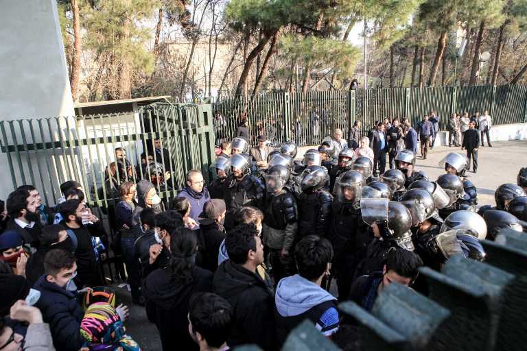 Estudiantes iraníes se enfrentan con la policía en la Universidad de Teherán durante una manifestación el 30 de diciembre de 2017. (AFP PHOTO / STR)