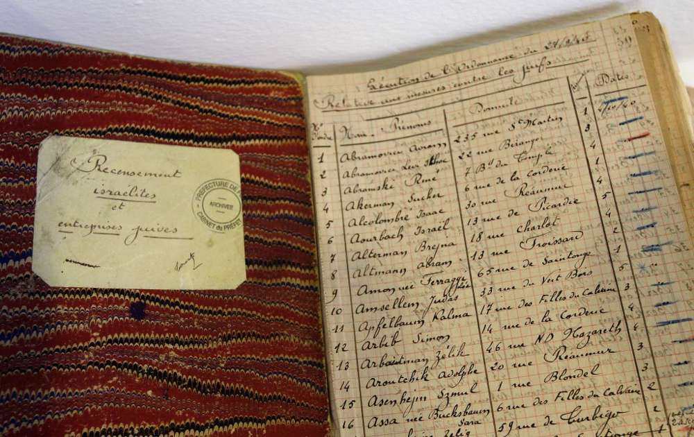 Los documentos procedentes de la Prefectura de la Policía de los Archivos de París que muestran listas de personas judías registradas durante la Segunda Guerra Mundial se presentan para una exposición de archivos franceses sobre la Shoah en París. Fotos, firmas y registros de objetos personales de muchas de las víctimas se exhiben en un ayuntamiento del distrito de París. (Crédito de la foto: AP Photo / Remy de la Mauviniere)