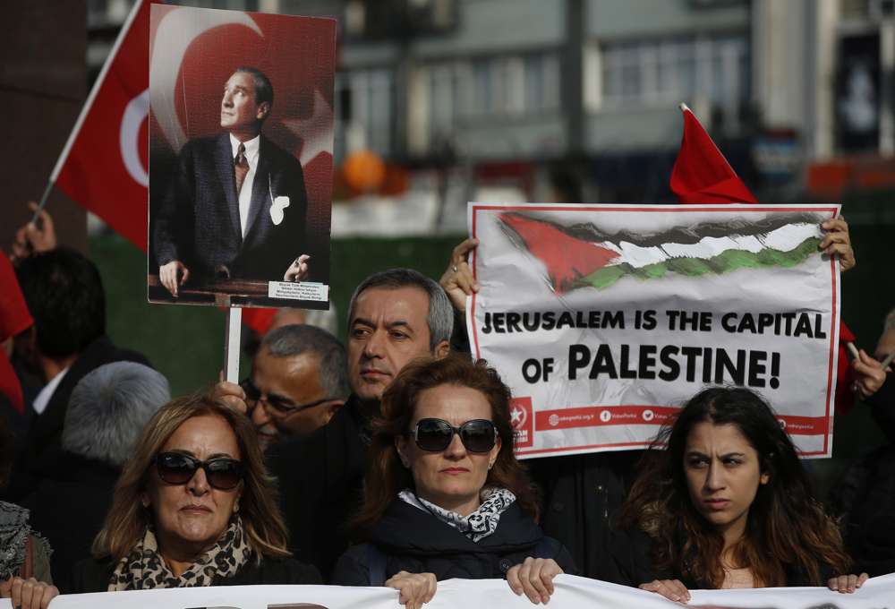 Manifestantes con banderas turcas y de la Autoridad Palestina y una pancarta de Mustafa Kemal Ataturk, el fundador de la Turquía moderna, entonan consignas antiestadounidenses durante una manifestación en Estambul, el sábado 9 de diciembre de 2017, contra la decisión del presidente estadounidense Donald Trump de reconocer Jerusalén en el capital de Israel. (AP Photo / Lefteris Pitarakis)