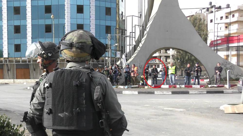 Terrorista musulmán Mohammed Aqal, escondido entre periodistas, antes de apuñalar a un oficial de la Policía de Fronteras el 15 de diciembre de 2017. (Policía de Israel)