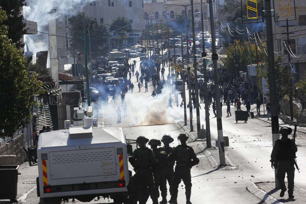 Árabes atacan a las tropas israelíes durante una protesta contra la decisión del presidente estadounidense Donald Trump de reconocer a Jerusalén como la capital de Israel en la ciudad de Belén, el viernes 8 de diciembre de 2017. (AP Photo / Nasser Shiyoukhi)