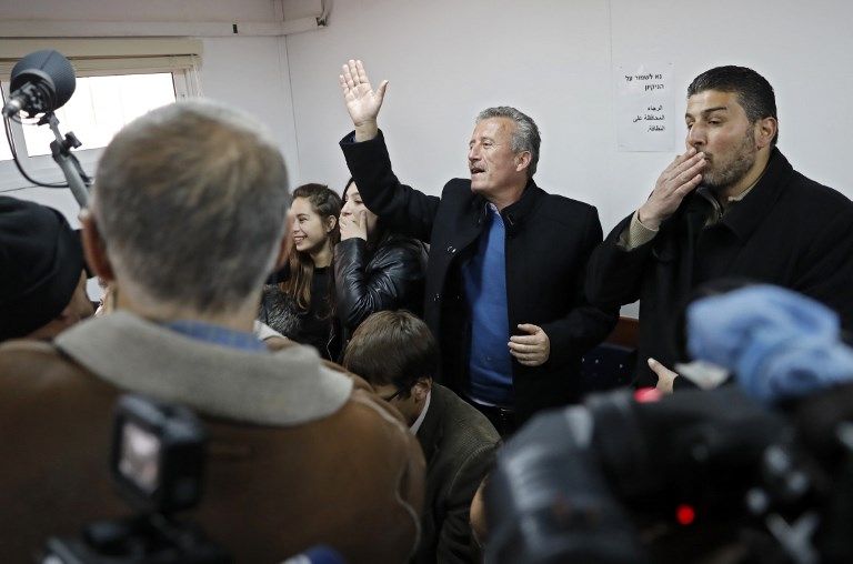 Bassem Tamimi (C), padre de la atacante árabe de 16 años, Ahed Tamimi, saluda a su hija durante una audiencia en el tribunal militar israelí en la prisión militar de Ofer el 15 de enero de 2018. (Thomas Coex / AFP)