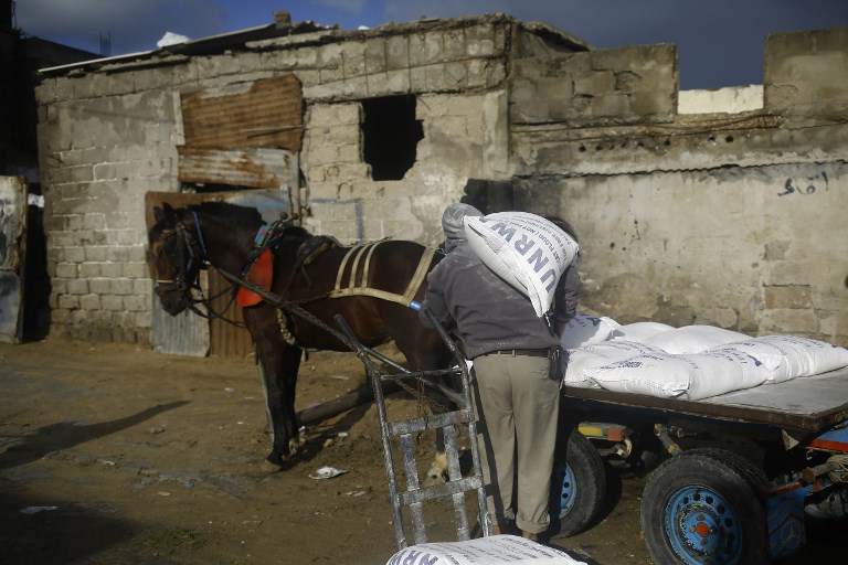 Un árabe carga un carro tirado por caballos con ayuda alimentaria fuera del centro de distribución de alimentos de las Naciones Unidas en la ciudad de Gaza el 15 de enero de 2018. (AFP Photo / Mohammed Abed)