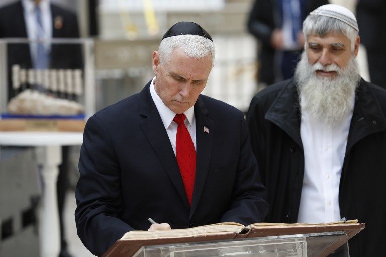 El vicepresidente de EE.UU. Mike Pence (izq.) Firma el libro de visitas durante una visita al Muro Occidental de Jerusalén el 23 de enero de 2018. (AFP PHOTO / Thomas COEX)