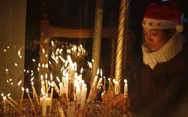 Uno de los cristianos ortodoxos enciende una vela en la Iglesia de la Natividad, construida sobre el sitio donde los cristianos creen que nació Jesus, en la víspera de Navidad, en la ciudad de Belén, el 24 de diciembre de 2016 (AP Photo / Majdi Mohammed)