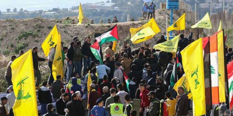 Soldados israelíes (arriba L) y fuerzas de paz de la ONU (arriba R) observan a los partidarios libaneses del movimiento chiita de Hezbollah presencian una manifestación contra la decisión del presidente estadounidense de reconocer a Jerusalem como la capital de Israel el 28 de enero de 2018 en la aldea libanesa del sur de Alma al-Shaab, en la frontera con Israel. (AFP / Mahmoud Zayyat)