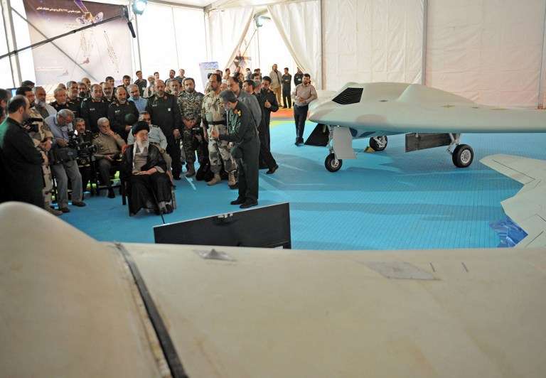 Una foto de la oficina de Khamenei , el Líder Supremo de Irán el 11 de mayo de 2014 lo muestra (CL) sentado al lado de un dron RQ-170 y su copia local en la exhibición de la Fuerza Aérea Espacial de la Guardia Revolucionaria Islámica en Teherán. (AFP / HO / sitio web del líder iraní)