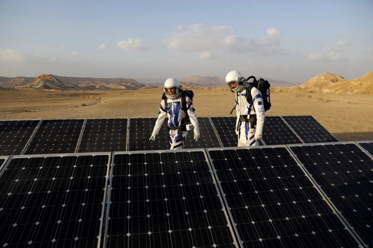 Los astronautas análogos israelíes caminan pat paneles solares cuando comienzan su misión en el Proyecto D-MARS el 18 de febrero de 2018. (AFP / MENAHEM KAHANA)