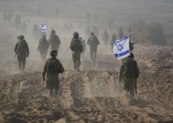 Soldados israelíes sostienen una bandera israelí mientras abandonan el territorio libanés durante un segundo día de alto el fuego durante la Segunda Guerra del Líbano, cerca de la ciudad de Menara el 15 de agosto de 2006 .. (Crédito de la foto: REUTERS)