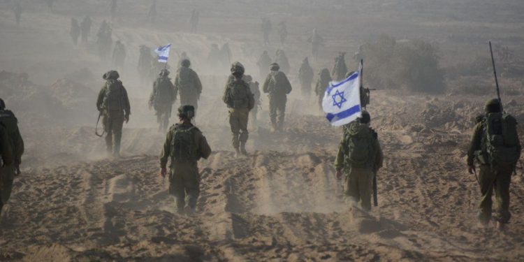 Soldados israelíes sostienen una bandera israelí mientras abandonan el territorio libanés durante un segundo día de alto el fuego durante la Segunda Guerra del Líbano, cerca de la ciudad de Menara el 15 de agosto de 2006 .. (Crédito de la foto: REUTERS)