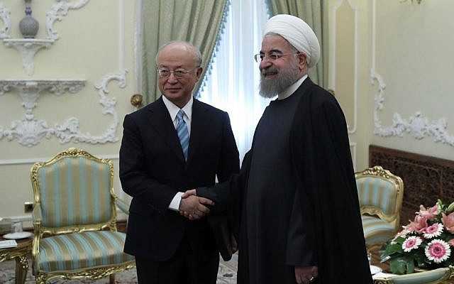 En esta foto publicada por el sitio web oficial de la oficina de la Presidencia iraní, el presidente Hassan Rouhani, a la derecha, y el director general de la Agencia Internacional de Energía Atómica, AIEA, Yukiya Amano se saludan ante los medios al comienzo de su reunión en la oficina de la Presidencia en Teherán, Irán, domingo, 18 de diciembre de 2016. (Oficina de la Presidencia iraní / AP)