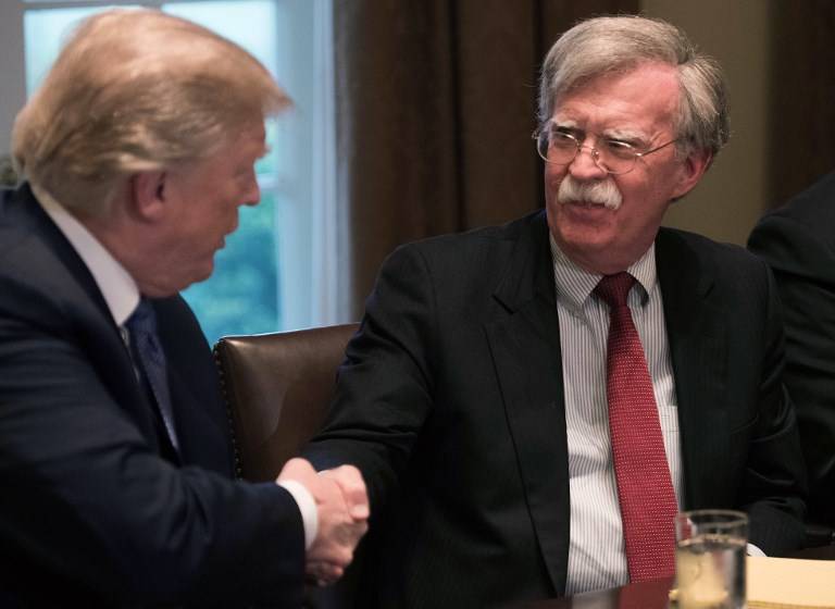 El presidente estadounidense, Donald Trump, estrecha la mano del asesor de Seguridad Nacional, John Bolton, durante una reunión con altos líderes militares en la Casa Blanca, el 9 de abril de 2018. (AFP Photo / Nicholas Kamm)