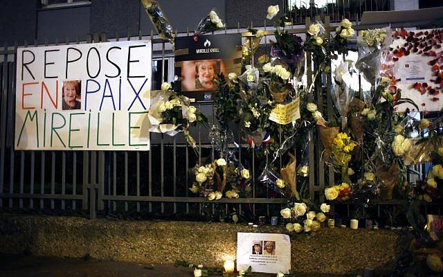 Flores y pancartas se exhiben fuera del apartamento de Mireille Knoll durante una marcha silenciosa en París, Francia, el miércoles 28 de marzo de 2018. (AP Photo / Thibault Camus)