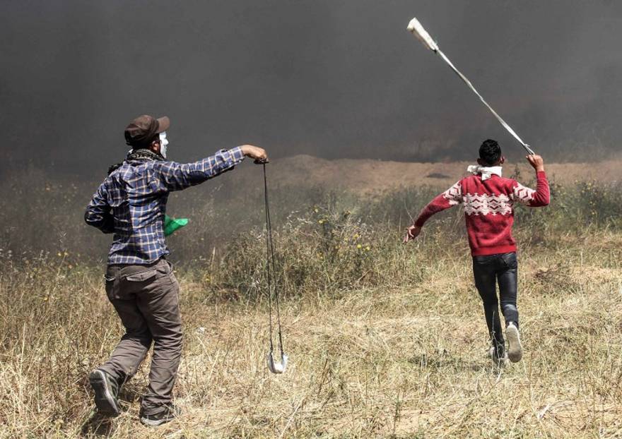 Islamistas palestinos utilizan hondas para lanzar piedras hacia las fuerzas de seguridad israelíes durante la violenta manifestación en la frontera entre Gaza e Israel en el sur de la Franja de Gaza el 6 de abril de 2018. (AFP PHOTO / SAID KHATIB)