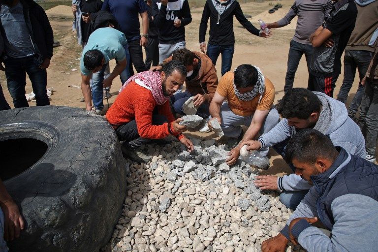 Islamistas de Gaza escogen las piedras más contundentes para atacar a los soldados de Israel que impiden la infiltración masiva (AFP / Mohammed Abed)