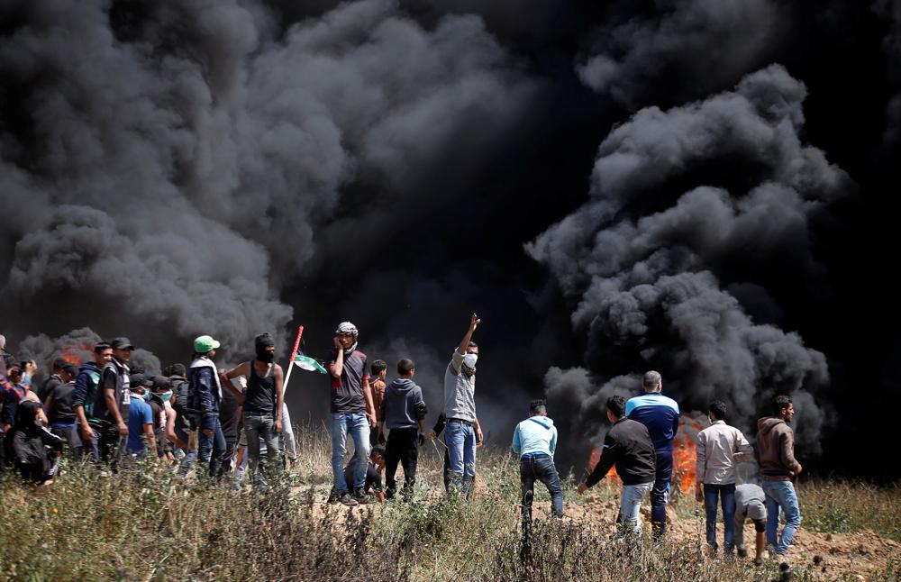 Los árabes palestinos queman neumáticos durante oleada de ataques islamistas contra las fuerzas de seguridad israelíes y un intento masivo de infiltración hacia Israel el 6 de abril de 2018. (AFP / Said Khatib)