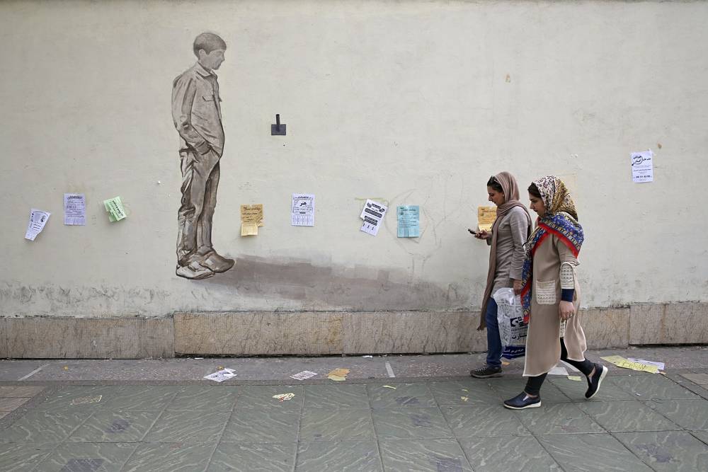 Mujeres se abren paso en una acera en el centro de Teherán, Irán, el 22 de abril de 2018. (Vahid Salemi / AP)