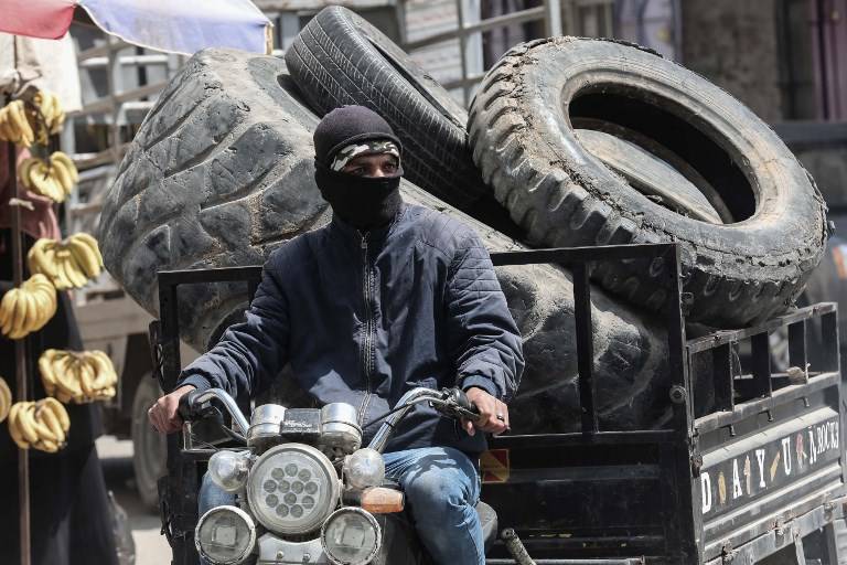 Un islamista de Gaza recoge llantas que serán quemadas durante las protestas a lo largo de la frontera de Gaza en Khan Younis, en el sur de la Franja de Gaza, el 4 de abril de 2018. (Said Khatib / AFP)