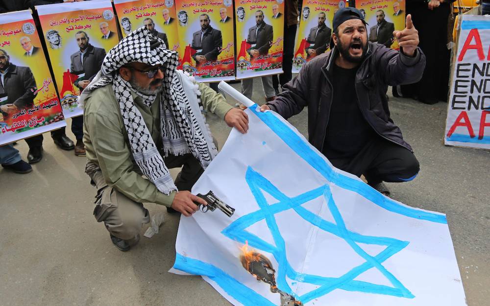 Palestinos queman una bandera israelí. (Foto: Ashraf Amra / APA Imágenes)