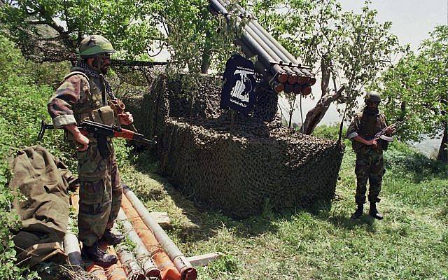 En esta foto de abril de 1996, dos combatientes del grupo terrorista libanés Hezbolá cerca de los cohetes Katyusha en la aldea sureña de Ein Qana, en el Líbano. (Foto AP / Mohammed Zaatari)