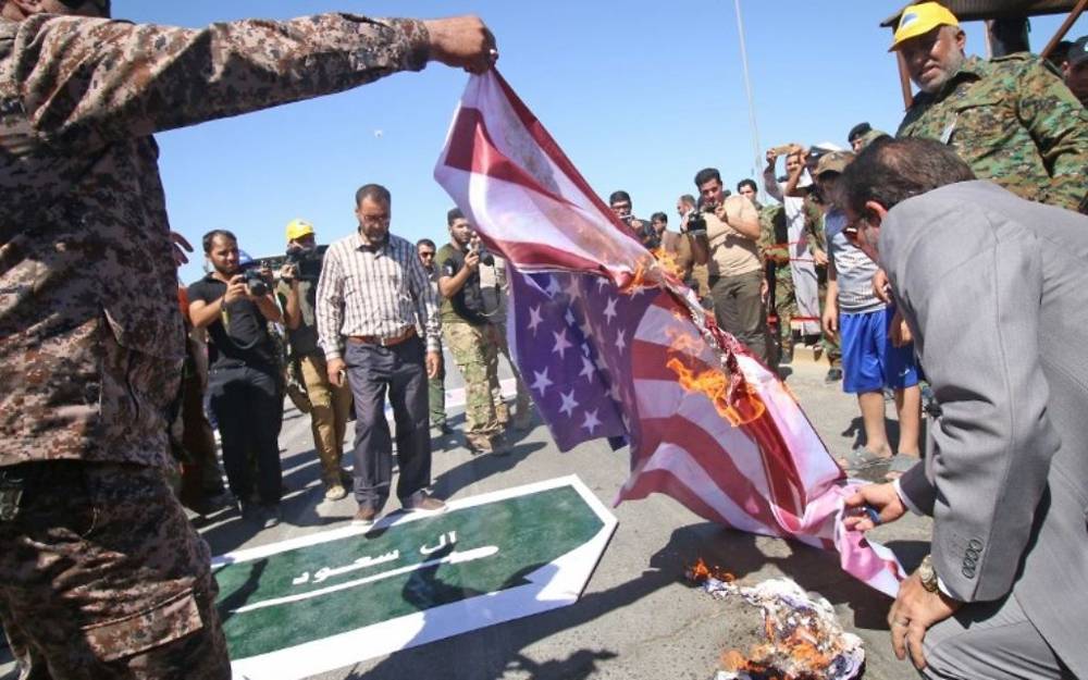 Ilustrativo: Hombres y niños iraquíes prenden fuego a las banderas de Estados Unidos y Arabia durante un desfile por el Día Internacional Al-Quds (Jerusalén) organizado por las unidades de Movilización Popular en la ciudad sureña de Basora, el 23 de junio de 2017. (AFP PHOTO / HAIDAR MOHAMMED ALI)