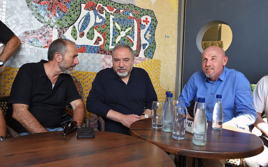 El ministro de Defensa Avigdor Liberman (C) se reúne con el jefe del Consejo Regional del Golán, Eli Malka (L) y el jefe del Consejo Regional de Katrzin, Dmitry Apartzev (R) durante una gira por la ciudad de Katzrin en los Altos del Golán el 11 de mayo de 2018. (Ariel Hermoni / Ministerio de Defensa)