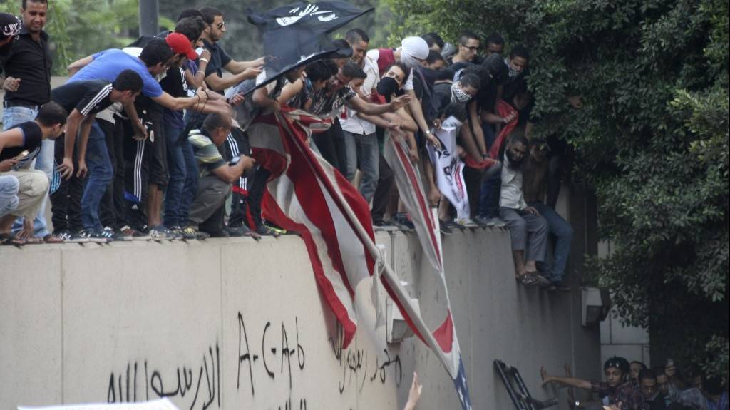 Los manifestantes destruyen una bandera estadounidense en la Embajada de los EE. UU. en El Cairo y la reemplazan con una bandera islámica negra. Treparon por las paredes y protestaban contra una película que consideraban ofensiva para el Islam. (Mohammed Abu Zaid, Foto AP)