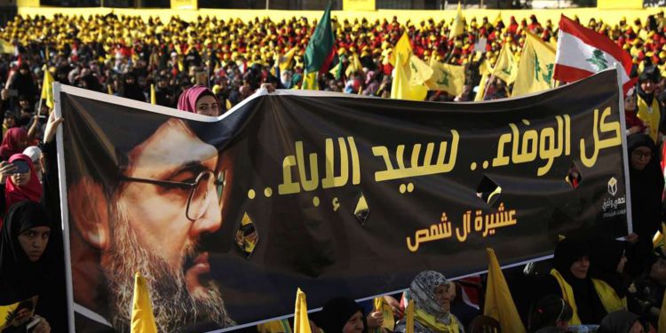 Los partidarios del líder de Hezbolá Hassan Nasrallah sostienen una pancarta con su retrato y palabras en árabe que dicen: “Toda la lealtad al hombre de la nobleza” durante un discurso de campaña electoral en un suburbio del sur de Beirut, Líbano. (AP / Hussein Malla)